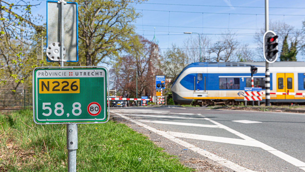 Verkeersbord N226 bij spoorwegovergang met passerende trein, locatie van kabels en leidingen project in provincie Utrecht