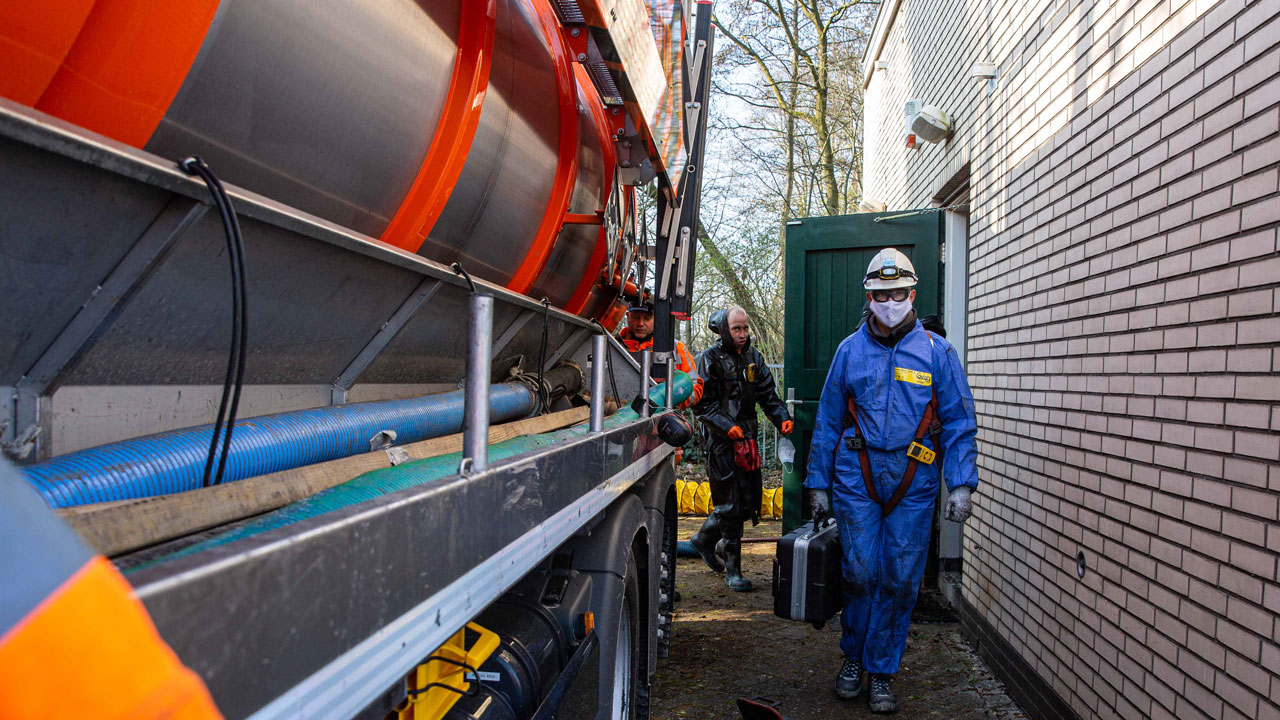 Specialisten voeren inspectie uit bij rioolgemaal met industriële reinigingswagen – focus op veiligheid en milieutechniek