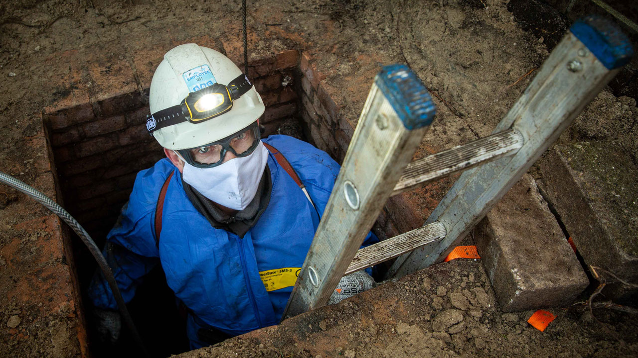 Medewerker in beschermende kleding klimt uit rioolgemaal tijdens onderzoek in Utrecht – focus op veiligheid en inspectie