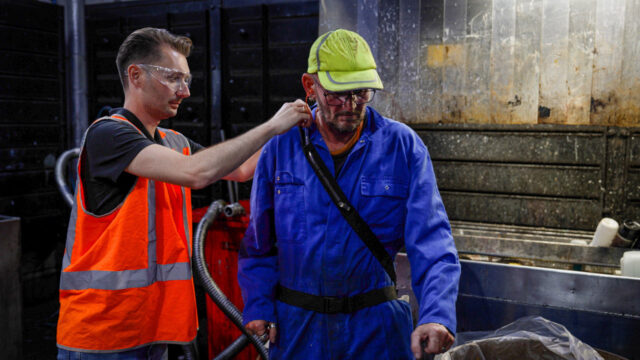 Begeleiding op werkvloer met beschermende kleding, illustratie van veilige instroom naar banen met risicovolle stoffen via Tetra Tech-trajecten