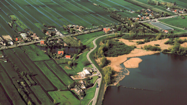 Luchtfoto van voorlanden langs Hollandsche IJssel met landbouw, bebouwing en water, in kader van veiligheidsbeoordeling waterkeringen