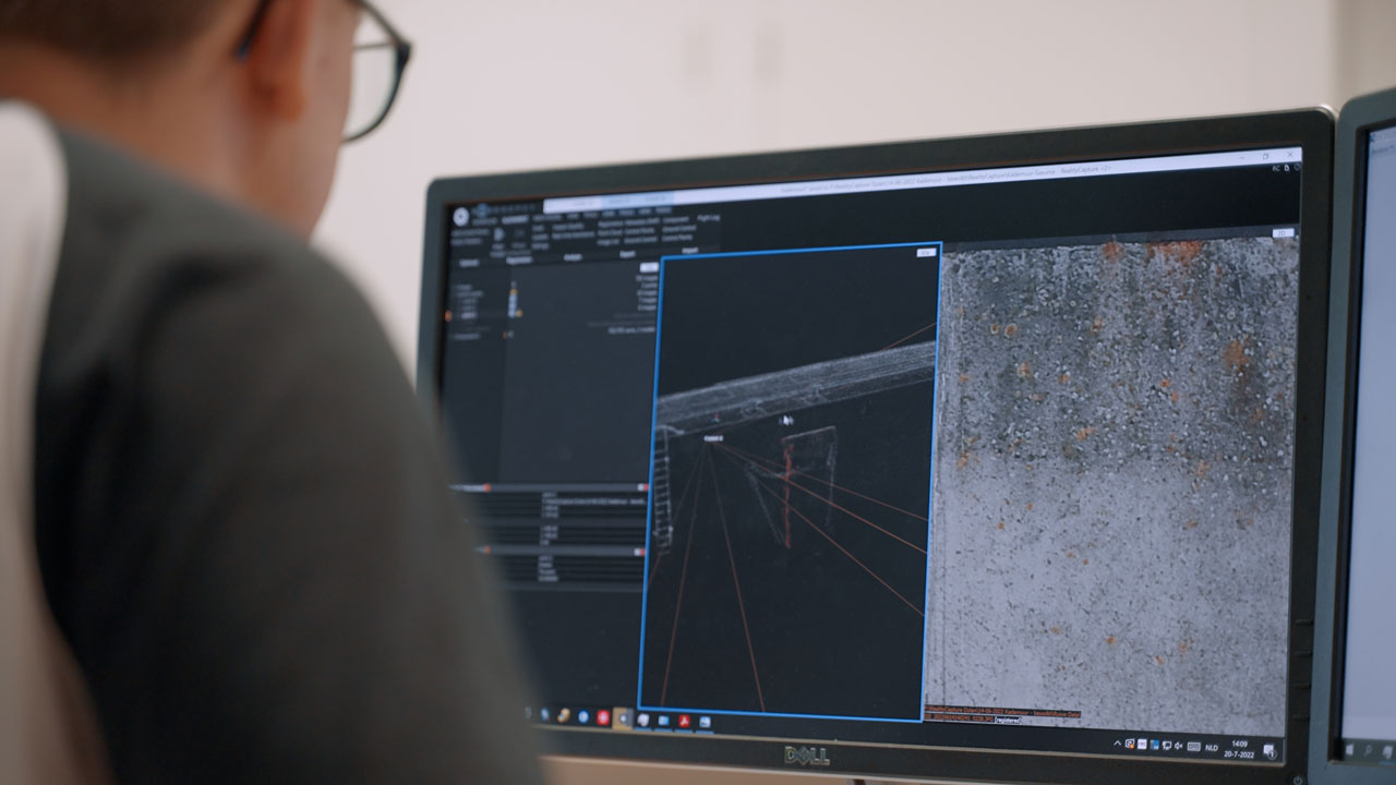 Medewerker analyseert inspectiedata van Eemshaven op computerscherm met meetvisualisaties en beeldmateriaal