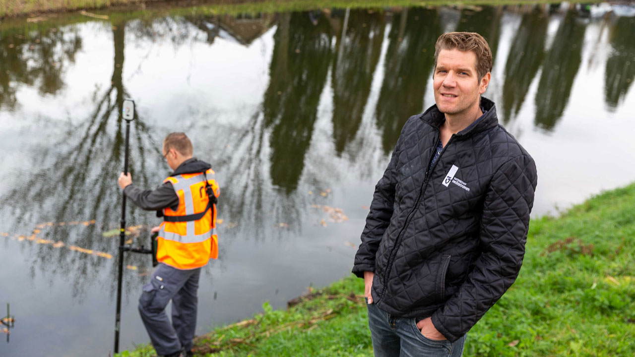 Medewerker van Waterschap Vechtstromen en een medewerker van Tetra Tech tijdens werkzaamheden aan oever, onderdeel van grootschalig onderhoud en monitoring van waterkwaliteit