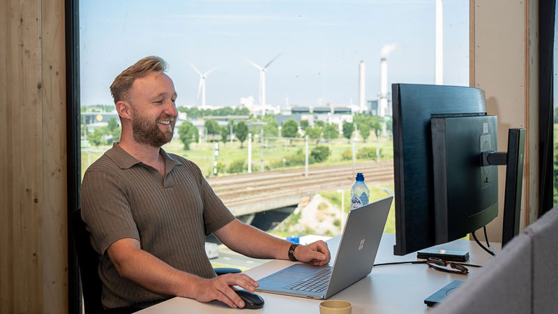 Jurist aan het werk achter computer met windmolens op de achtergrond