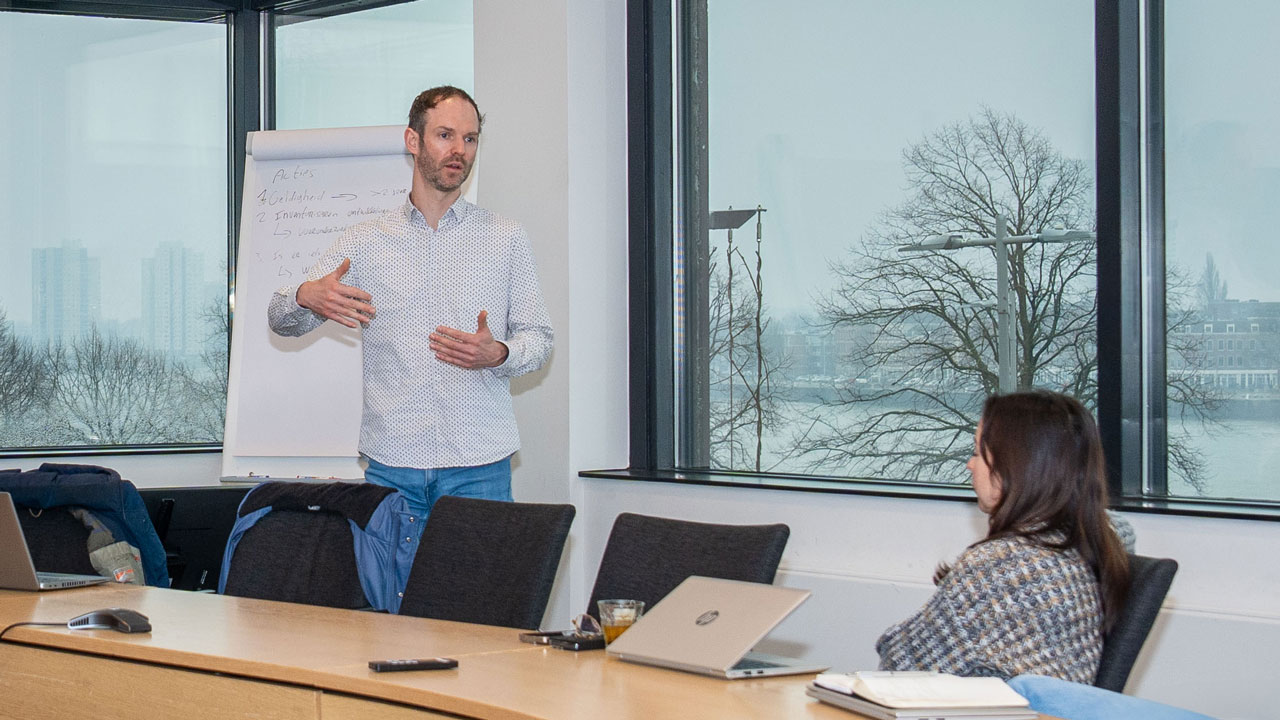 Man legt staand uit aan collega's