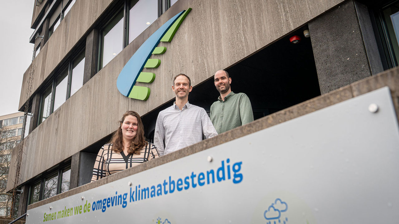 Drie collegas poseren voor kantoor