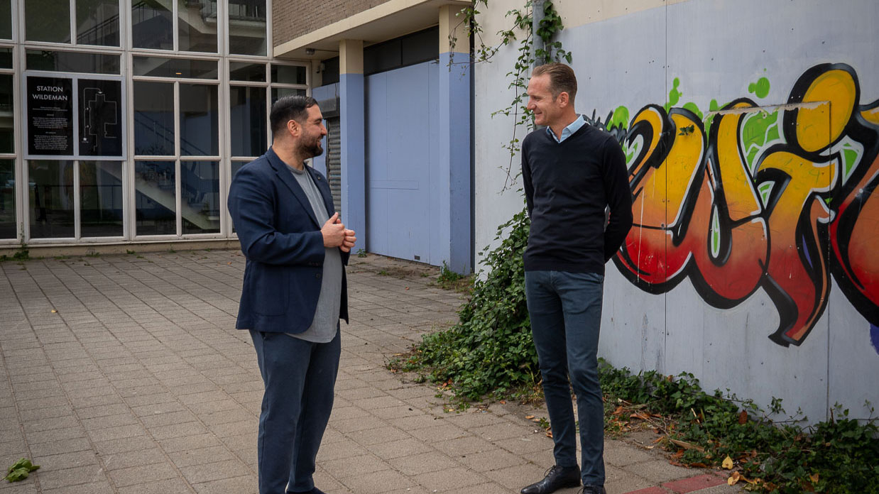 Twee mannen overleggen op het schoolplein