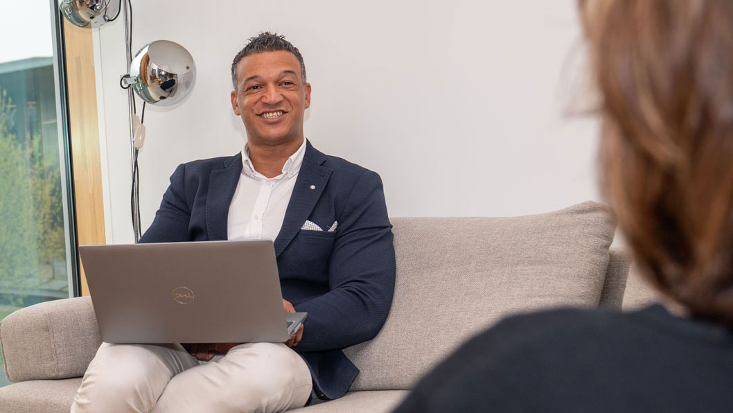 Specialist met laptop op schoot in overleg