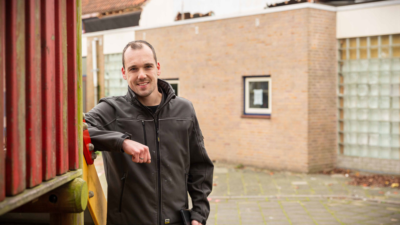Persoon bij oud schoolgebouw Sterrenwerk met zicht op beschadigd dak, circulair gesloopt in opdracht van Gemeente Teylingen