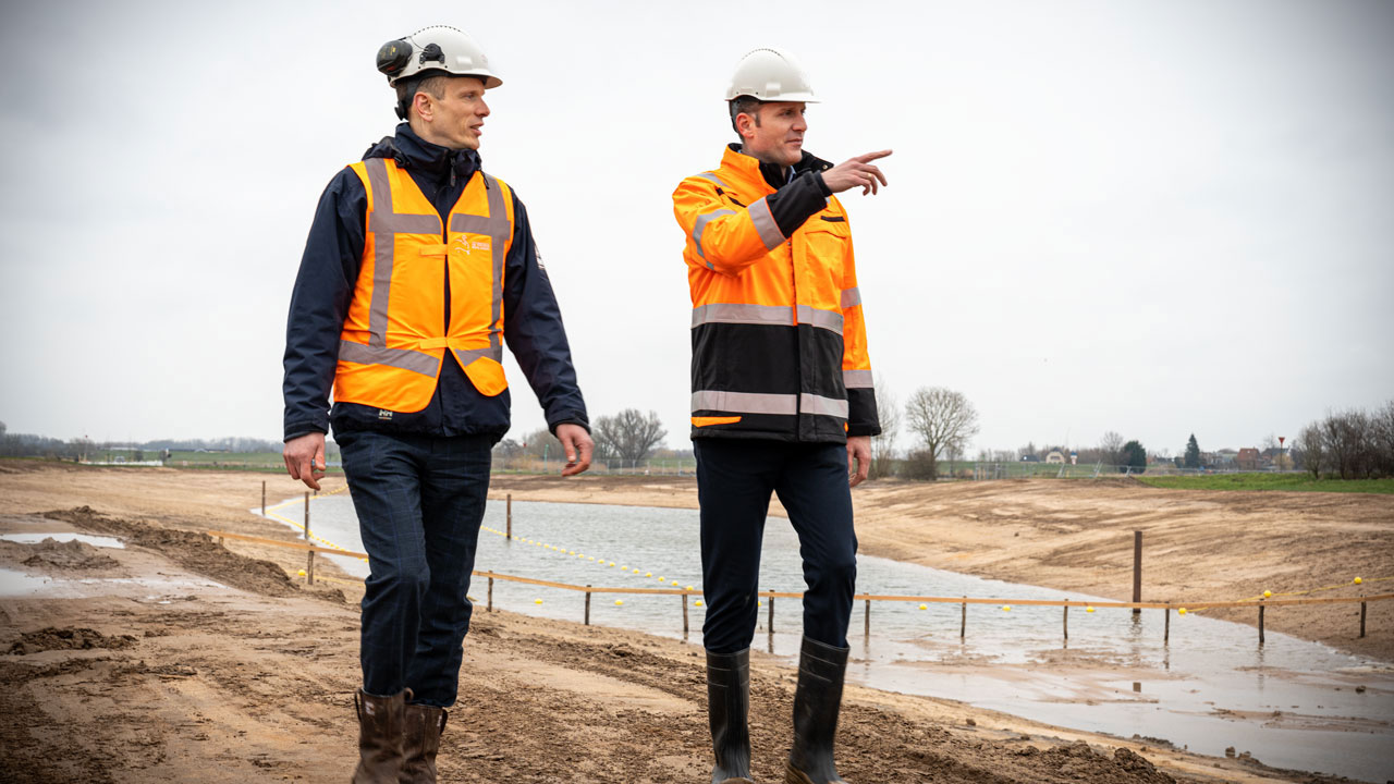 Twee experts inspecteren dijkversterking op bouwlocatie – onderdeel van project De Dijk van de Toekomst