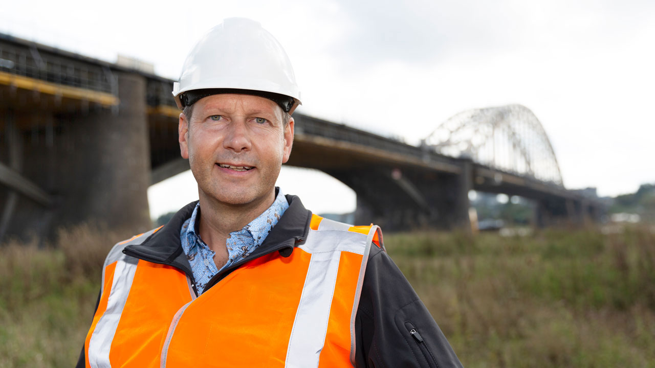 Tetra Tech-expert Jan Willem Peters bij bruginspectie voor chroom-6-verwijdering, met zicht op civiel kunstwerk in groene omgeving