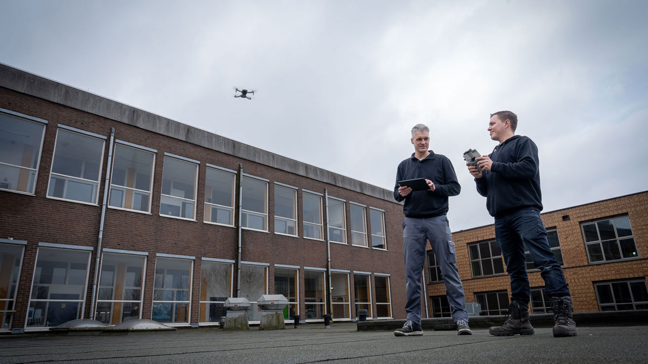 Twee collega's overleggen bij schoolgebouw