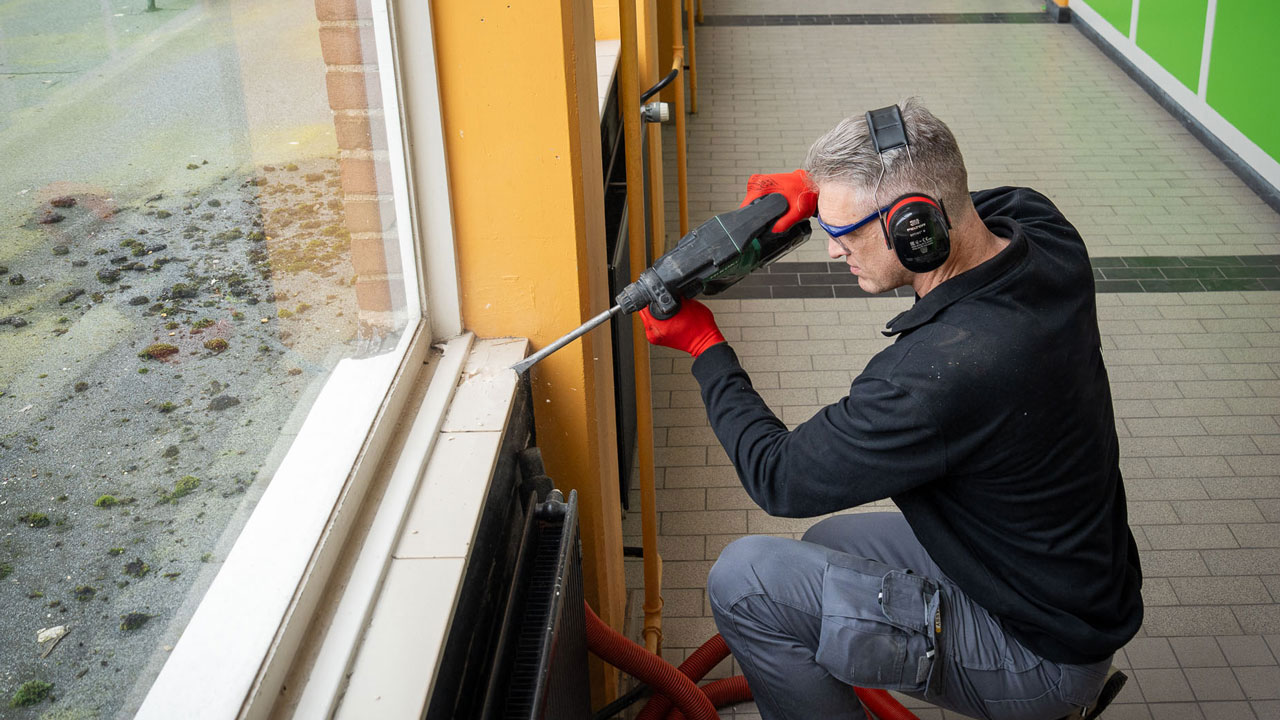 Man neemt een monster van schoolgebouw
