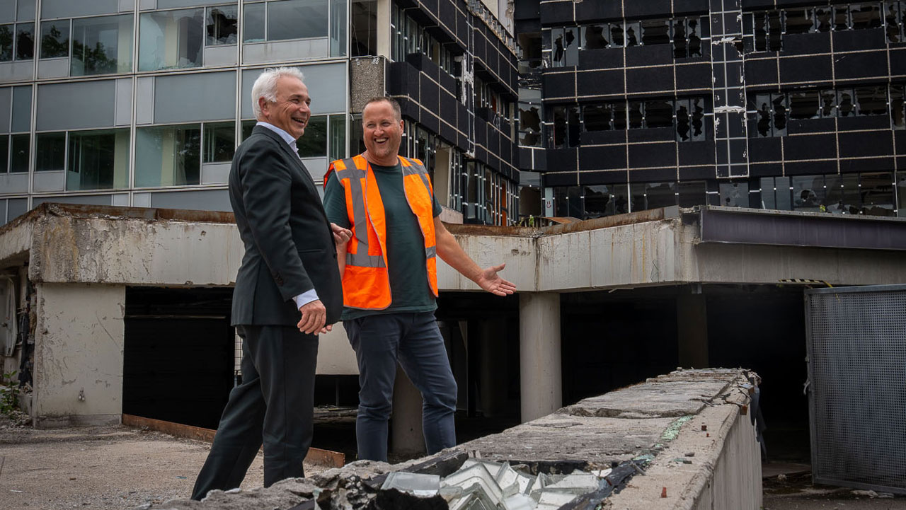 Twee lachende mannen op sloop locatie van oude school
