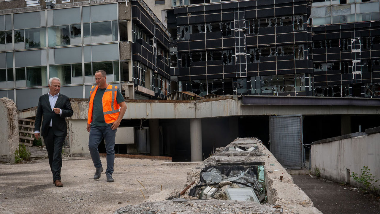 Twee mannen lopend op sloop locatie van oude school