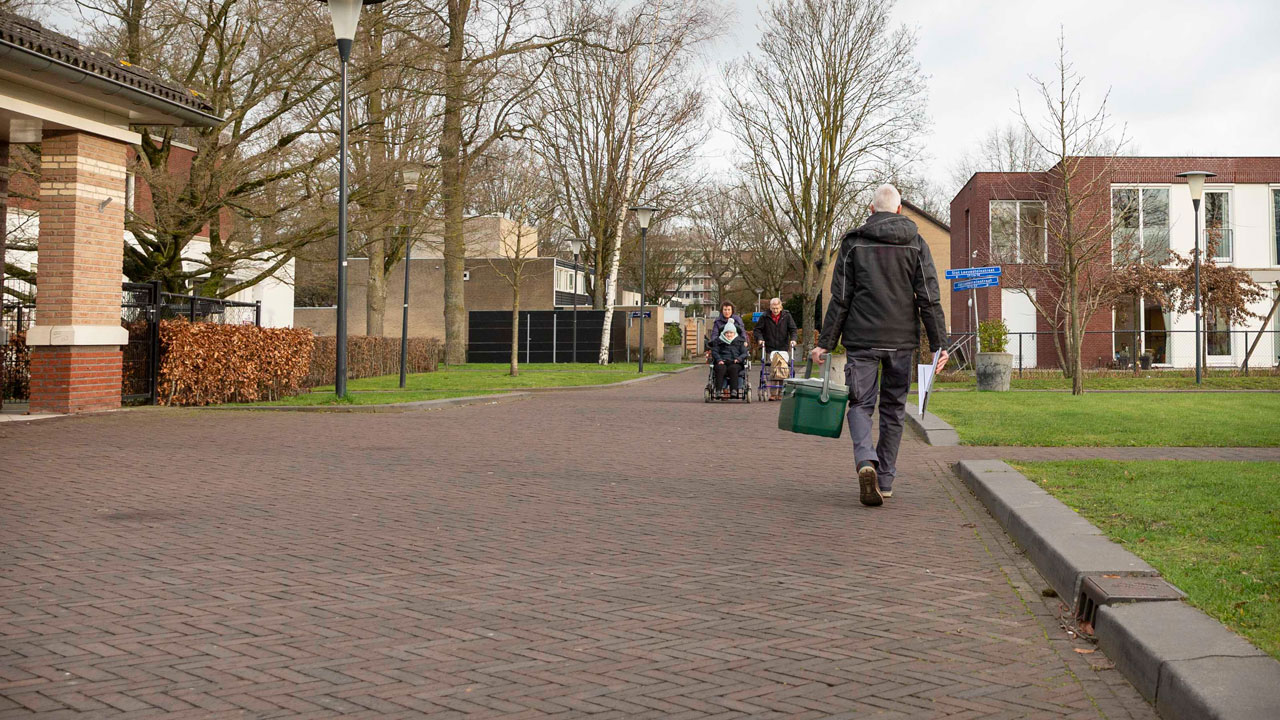 Straatbeeld bij zorginstelling Amarant met bewoners en begeleiders, in kader van legionellapreventie en veilige leefomgeving