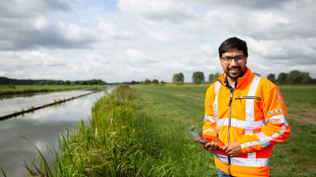 Medewerker voert oeverinspectie uit. Deskundig advies en monitoring voor duurzame oeverbescherming