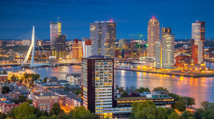Aanzicht verlichte gebouwen en brug van Rotterdam tijdens de avond