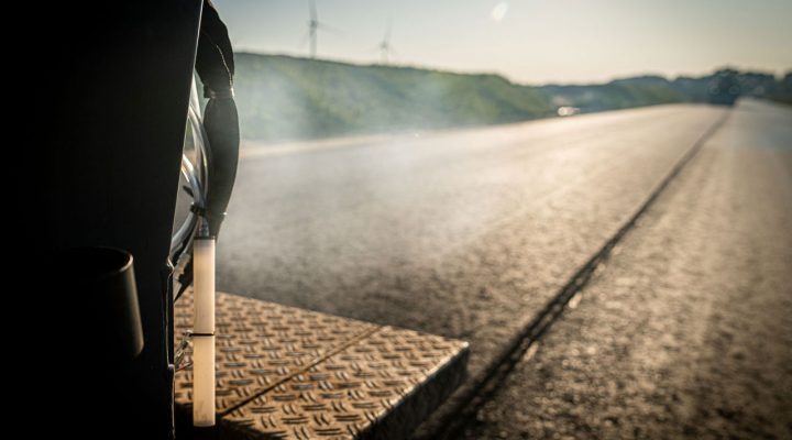 Vers aangelegd asfalt wat nog rookt, gezien van de achterkant van een asfalteermachine