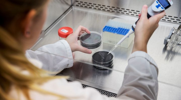 Laboratoriummedewerker plaatst monsterflesje in autosampler voor analyse