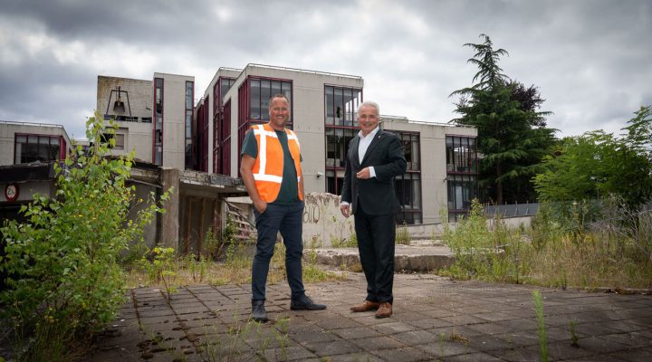 Twee mannen voor een oud schoolgebouw