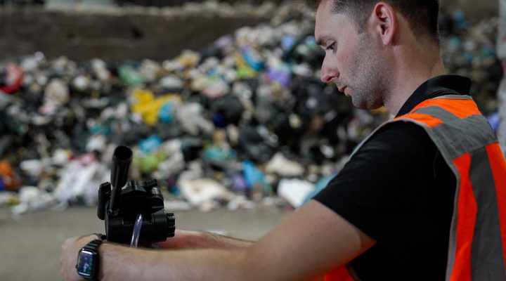 Arbeidshygiënist voert luchtmetingen uit bij een afvalverwerkingsbedrijf