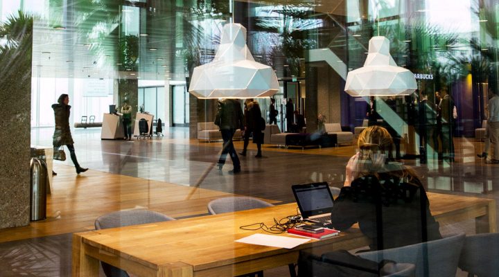 Moderne kantoorruimte met veel daglicht, houten vloer en werkplek, gericht op duurzame en energie-efficiënte werkomgeving