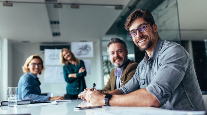 Overleg over vergunningen in kantoorruimte met documenten en visualisaties op de achtergrond